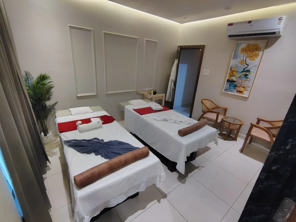 Dual-bed treatment suite with soft lighting and seating at Body Spa and Wellness