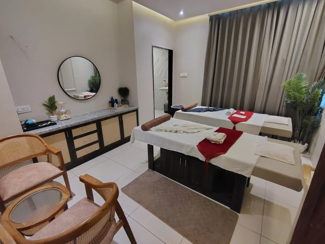 Dual-bed spa room with vanity, mirror and seating at Body Spa and Wellness